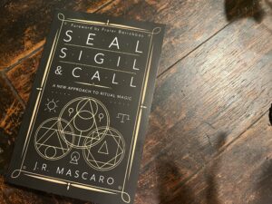 Devin Hunter of Modern Witch in font of Seal, Sigil, and Call by J.R. Mascaro