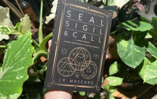 Devin Hunter holding a copy of Seal, Sigil, & Call by J.R. Mascaro